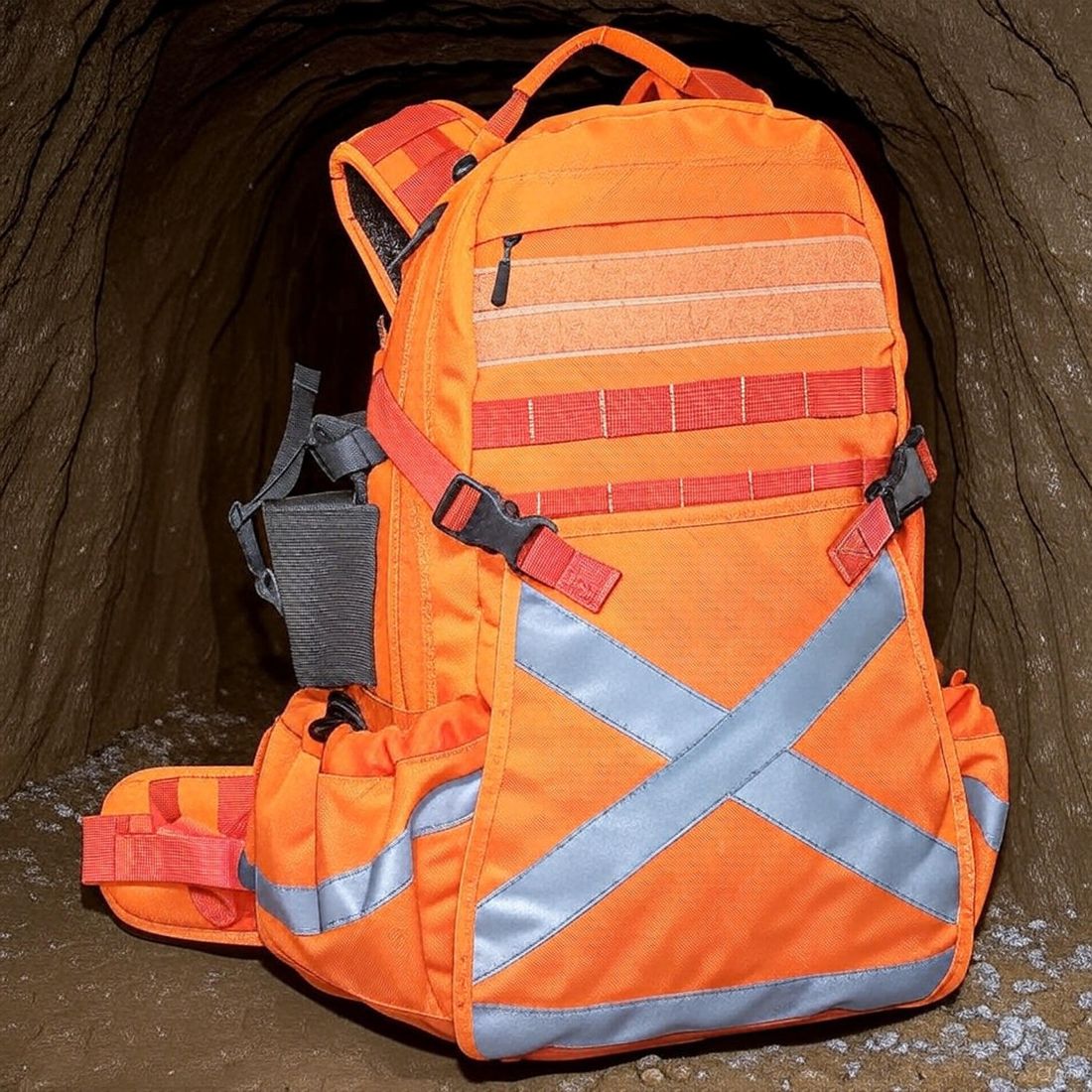 OPC Hi-Viz orange backpack with retroreflective X pattern, in an underground drift